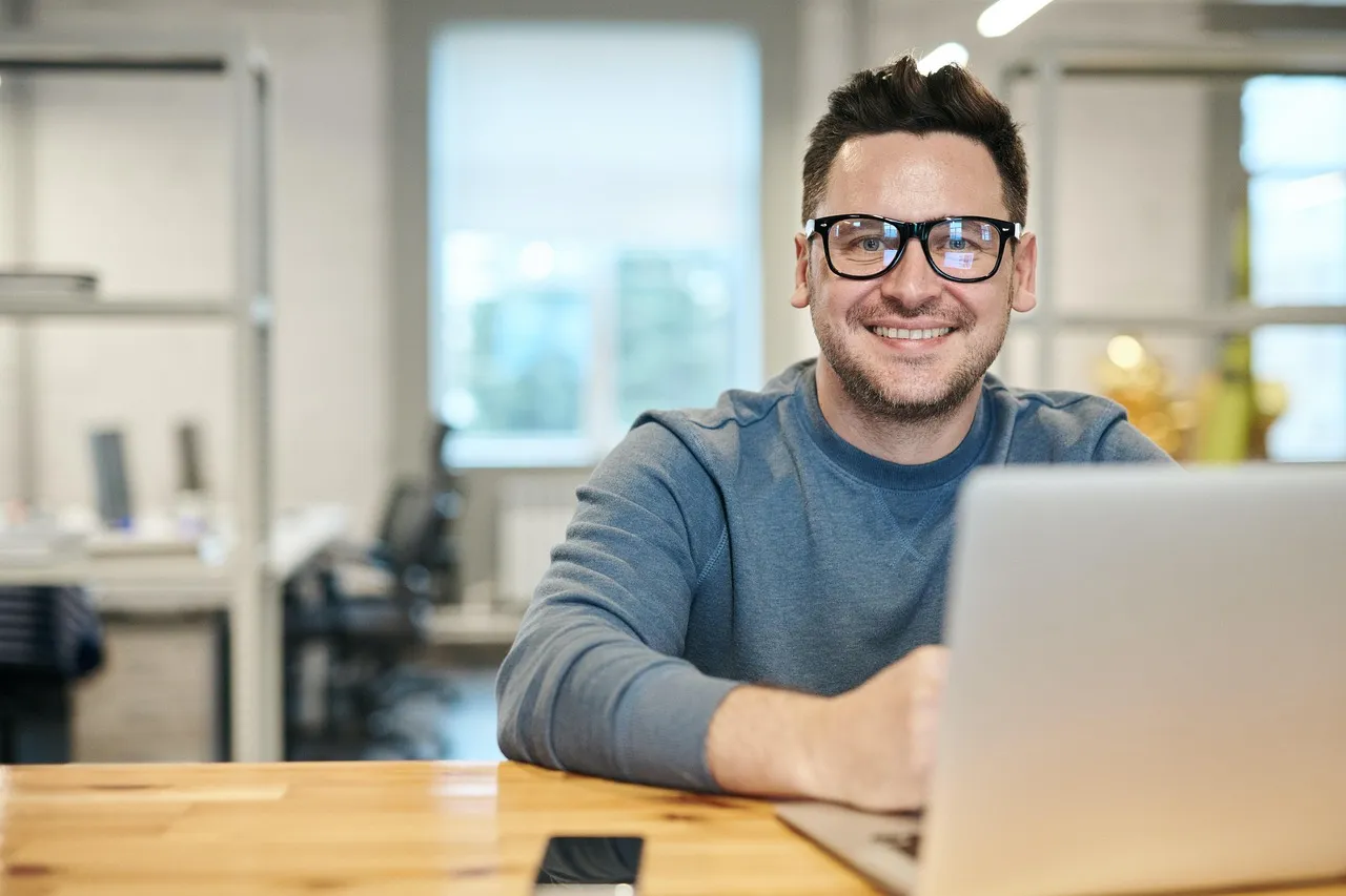 A smiling contractor working on a laptop